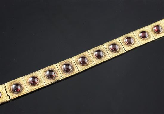 A Victorian engraved gold and cabochon almandine garnet hinged link bracelet, 6.5in.